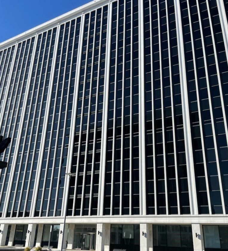 Front of a large office building with the front being mostly windows